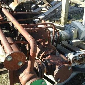 Rusty industrial machinery on grassy ground.