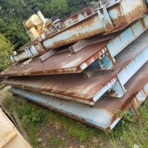 Stacked rusty metal plates outdoors.