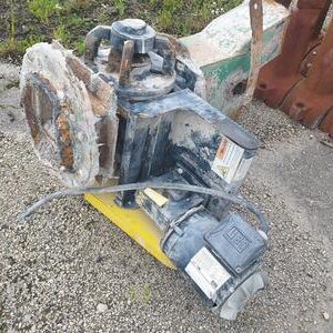 Rusty mechanical equipment on gravel ground.