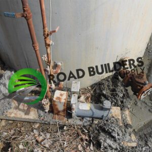 Pipes and valve near concrete structure.
