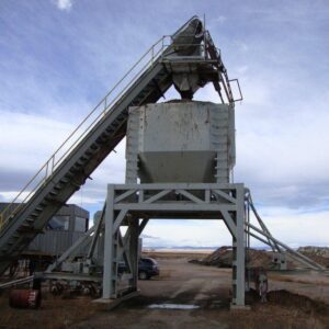 Industrial conveyor belt in a rural setting.