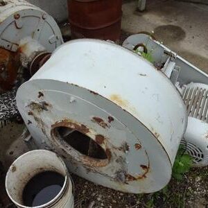 Old, rusted industrial machinery on concrete ground.