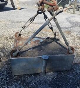 Rusty industrial lifting equipment on gravel.