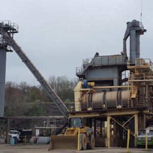 Industrial facility with silos and machinery outdoors.