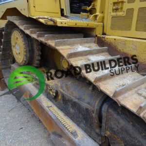 Yellow bulldozer tracks on rough terrain.