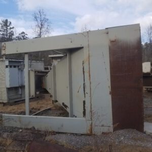 Large rusted metal structure on ground.