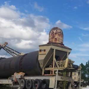 Rusty industrial machinery under cloudy sky.