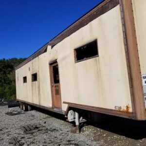 Old trailer in a gravel lot.