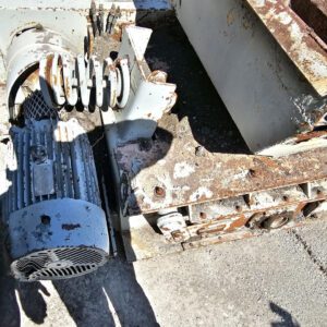 Old rusted industrial machinery on concrete ground.