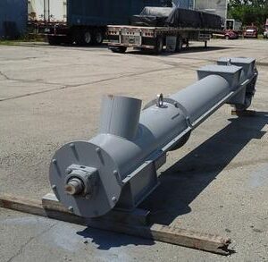 Large industrial gray screw conveyor on ground.