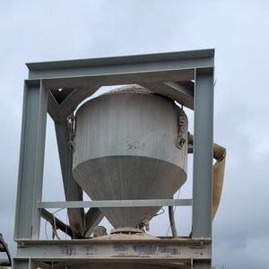 Large industrial hopper under cloudy sky.