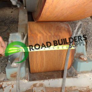 Measuring rusty industrial roller with tape measure.