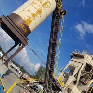 Industrial cement plant with silo and machinery.