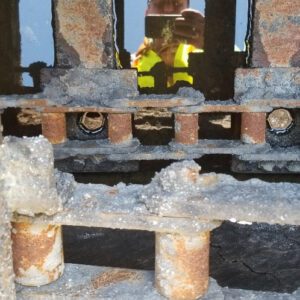 Rusty metal structure with visible corrosion damage.