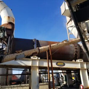 Rusted rotary drum and piping on platform