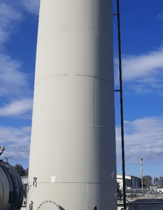 Large industrial storage tank under blue sky.