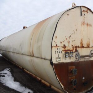 Large, rusted industrial storage tank outdoors.