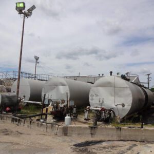 Industrial storage tanks under cloudy sky.