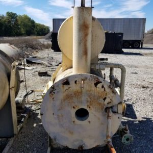 Rusted industrial equipment on gravel surface outdoors.
