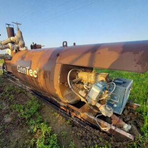 Rusty industrial machinery in outdoor grassy area.