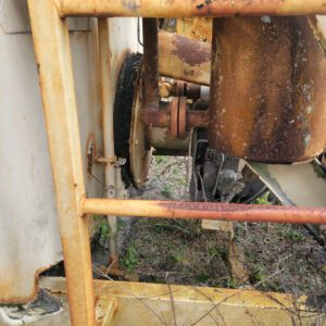 Rusty machinery with worn metal components outdoors.