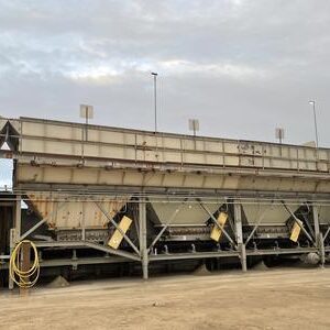 Mobile aggregate storage hoppers beside vehicle