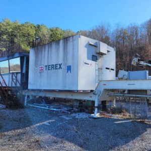 Terex machinery in a wooded industrial area.