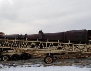 Old industrial conveyor on a snowy field.