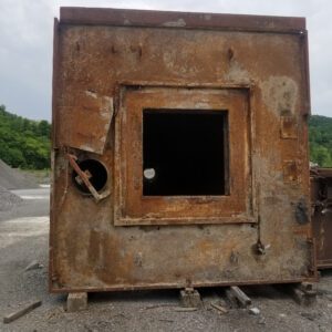 Rusty metal container with square opening.