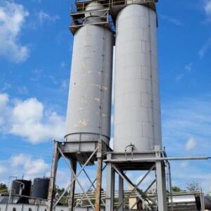 Two industrial silos under blue sky.