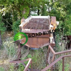 Old rusty industrial equipment in overgrown area.