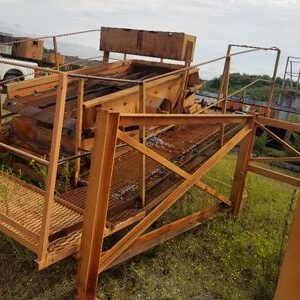 Rusty industrial machinery on grassy field.
