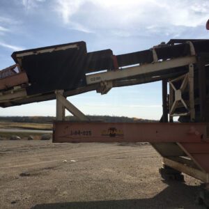 Industrial conveyor belt under a clear sky.