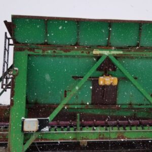 Green industrial machinery in snowy weather.
