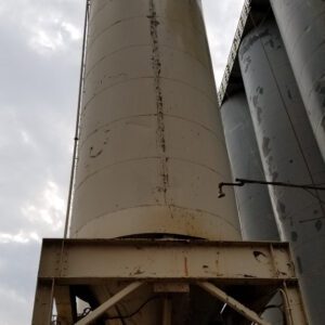 Large industrial silo under cloudy sky.