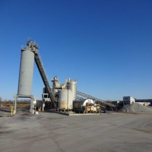 Industrial plant with silos under clear sky.