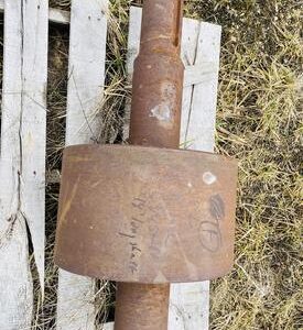 Rusty metal cylinder on wooden pallet.