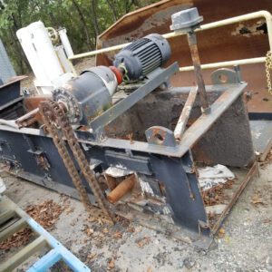 Rusty industrial machinery with chain and motor.