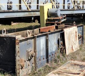 Rusty industrial equipment on grassy ground.