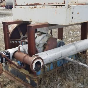 Rusty industrial equipment on grassy field.