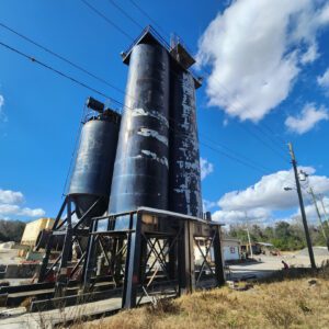 Peeling paint silos looming against blue sky