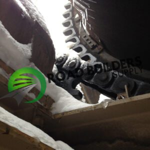 Snow-covered industrial machinery with Roadbuilders Supply logo.