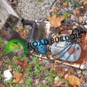 Old motor and pipes on ground.