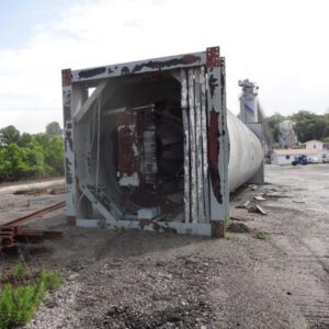 Fallen silo lying on gravel ground.