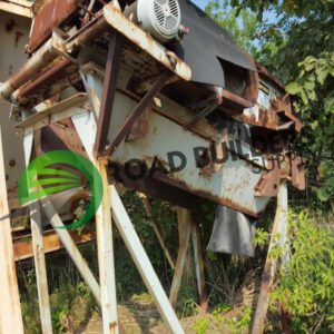Rusty industrial equipment surrounded by greenery.