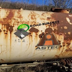 Rusty industrial tank with logos outdoors.