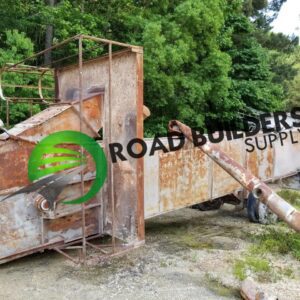 Rusty industrial equipment outdoors near trees.