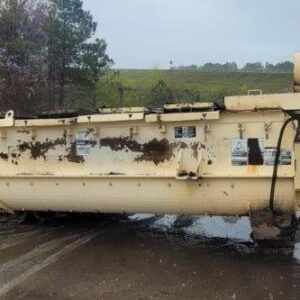 Large industrial machine lying on wet ground.