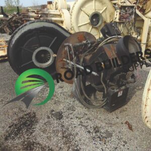Industrial machinery parts on a gravel surface.