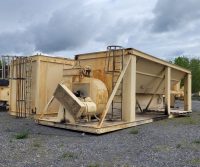 Rusty industrial machinery on gravel lot.